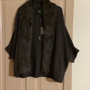 Cable stitch cape type sweater with detachable fur collar.